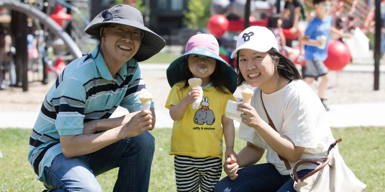 Family enjoying icecream at an outdoor event.