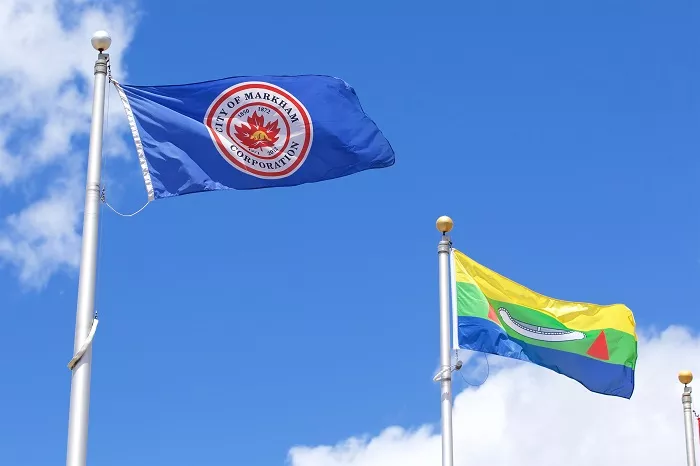 Flags of Eabametoong First Nation and the City of Markham flying outside Markham Civic Centre.