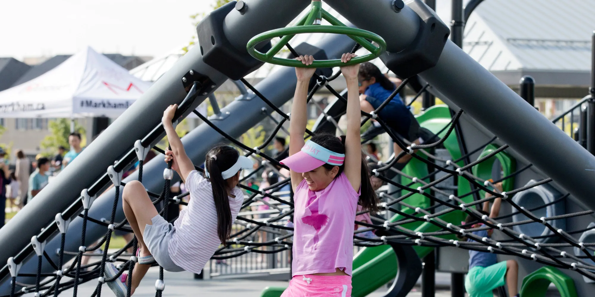 Two children climbing an outdoor play structure.