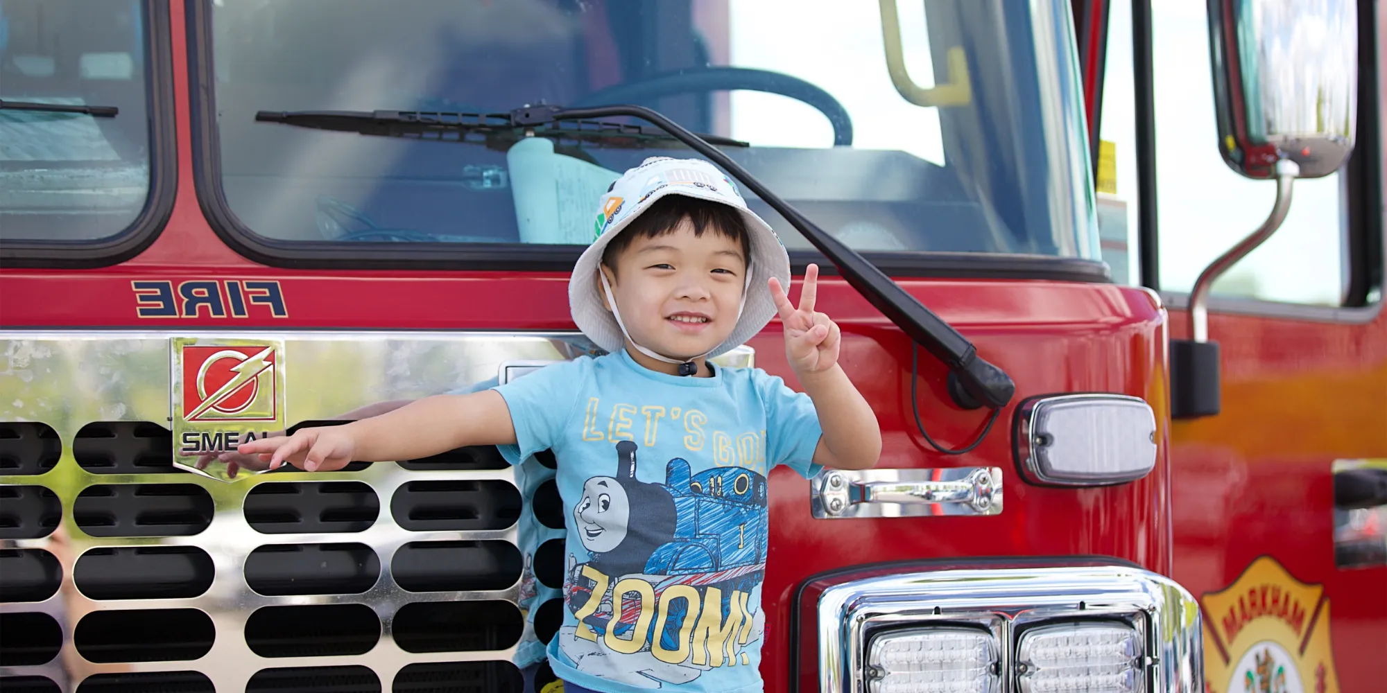 A young child posed in front of a City of Markham fire truck.