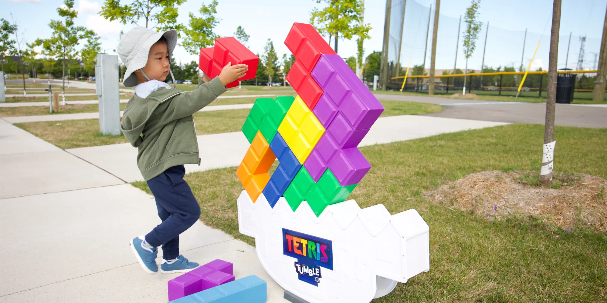 Young child stacking large Tetris pieces.